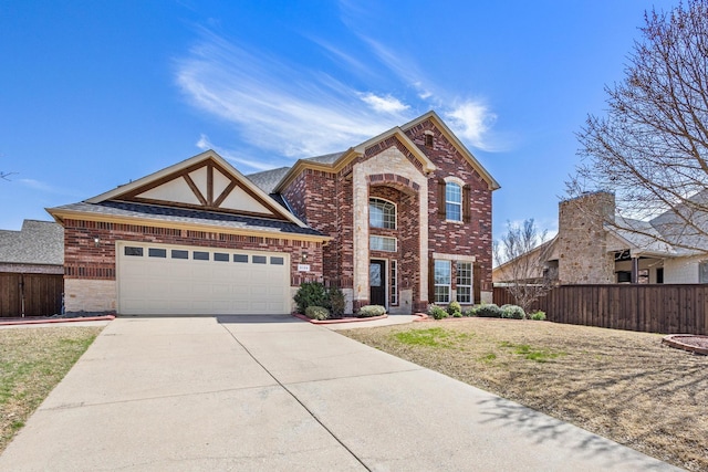 traditional-style house featuring fence, an attached garage, driveway, and brick siding