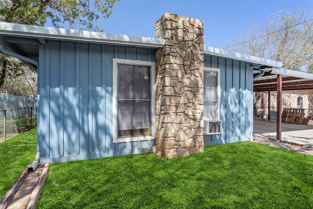 view of property exterior with board and batten siding, a chimney, and a carport