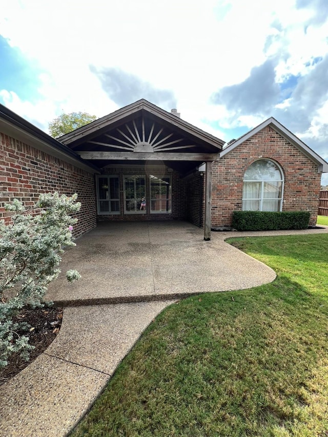 2449 Elm Leaf Ln, Plano, TX 75025 - property entrance featuring a patio, a yard, and brick siding