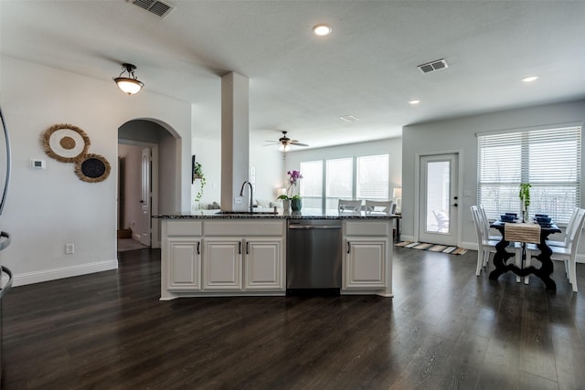 kitchen with dishwasher, visible vents, dark wood-style floors, and dark stone countertops