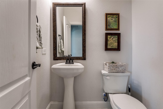 bathroom with baseboards and toilet