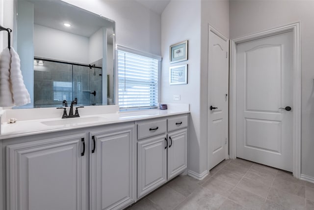 full bathroom featuring tile patterned flooring, baseboards, vanity, and tiled shower