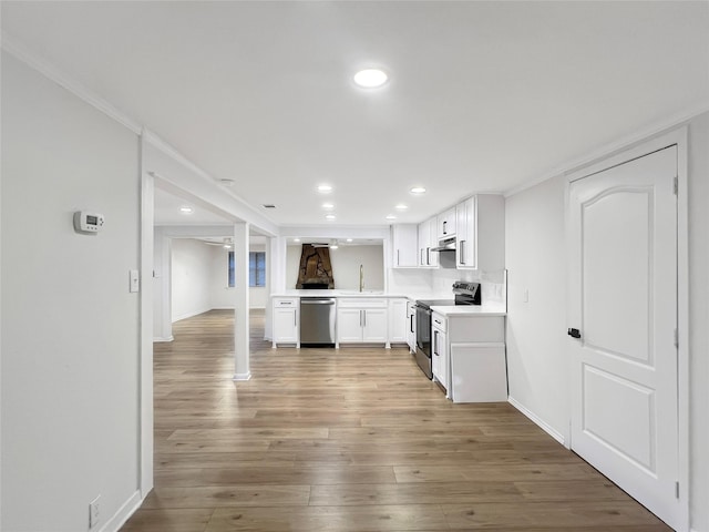 kitchen featuring wood finished floors, under cabinet range hood, recessed lighting, and appliances with stainless steel finishes