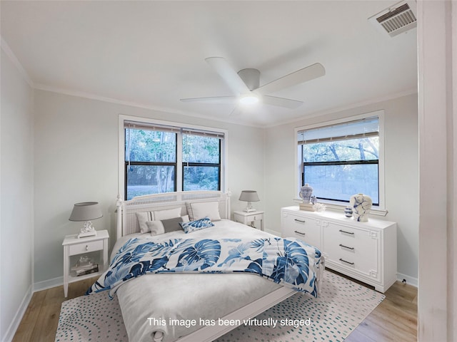 bedroom featuring light wood-style flooring, visible vents, and multiple windows