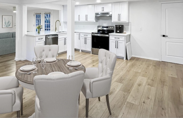 interior space featuring a sink, open floor plan, stainless steel appliances, light countertops, and under cabinet range hood