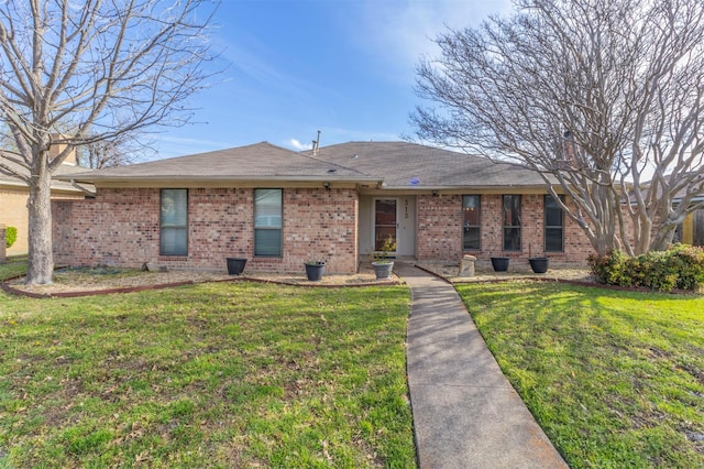 view of front of house featuring brick siding and a front yard