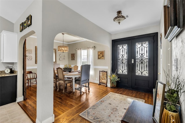 4933 County Road 340, Mckinney, TX 75071 - foyer entrance featuring arched walkways, light wood-type flooring, french doors, and a notable chandelier