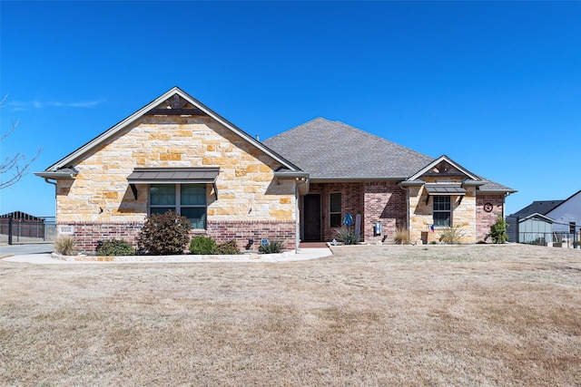 view of front of property with a gate, brick siding, fence, a shingled roof, and stone siding