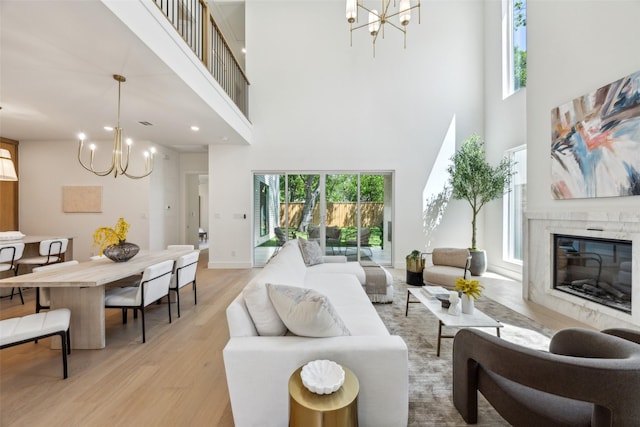 4415 Merrell Rd, Dallas, TX 75229 - living room featuring a chandelier, a high ceiling, light wood-type flooring, a premium fireplace, and recessed lighting