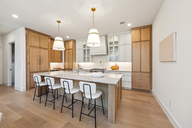 4415 Merrell Rd, Dallas, TX 75229 - kitchen featuring premium range hood, backsplash, a sink, a breakfast bar, and recessed lighting