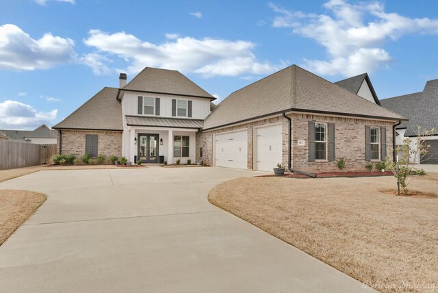 view of front facade featuring french doors, roof with shingles, concrete driveway, a garage, and brick siding