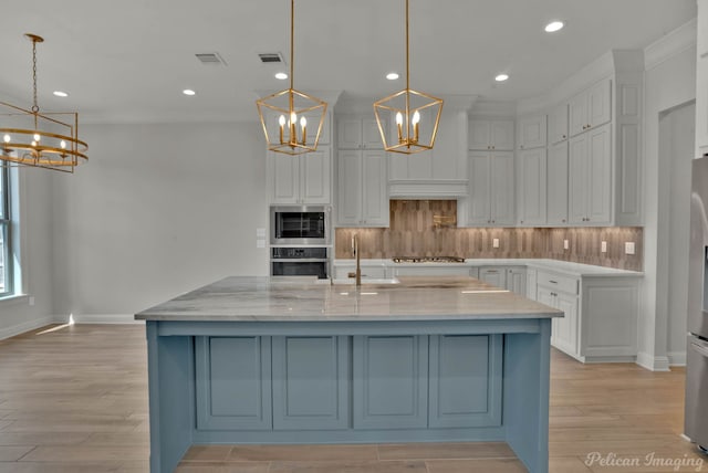kitchen featuring a sink, visible vents, tasteful backsplash, and a notable chandelier