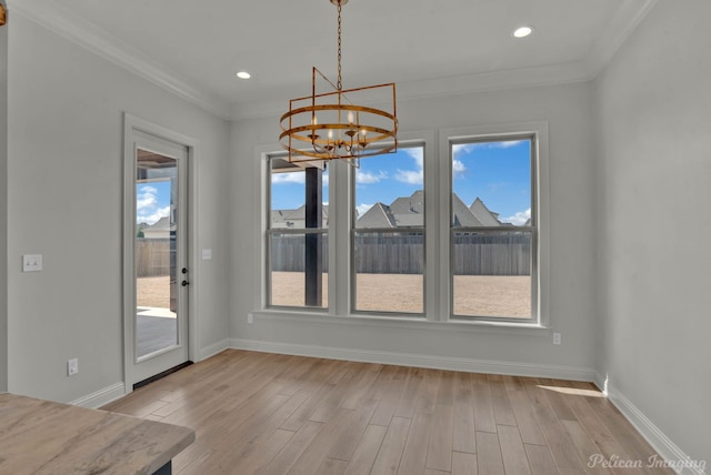 unfurnished dining area featuring light wood-style floors, a healthy amount of sunlight, and a chandelier
