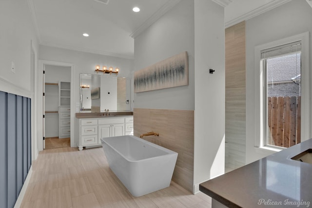 bathroom with recessed lighting, a walk in closet, vanity, and crown molding