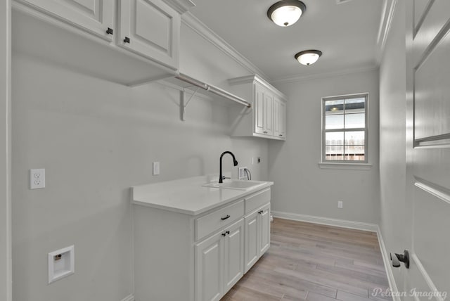 washroom featuring washer hookup, ornamental molding, a sink, cabinet space, and hookup for an electric dryer