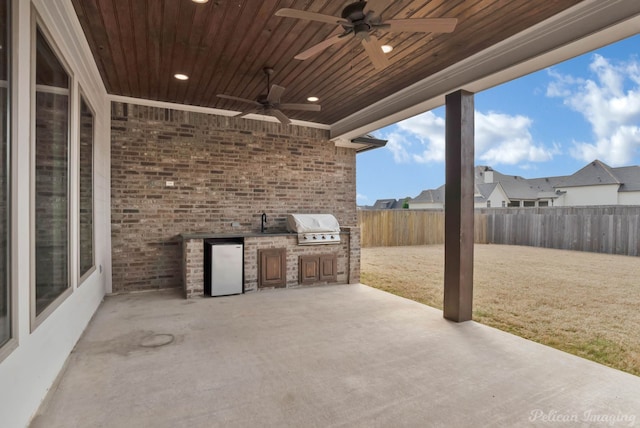 view of patio featuring area for grilling, a grill, a fenced backyard, and a ceiling fan