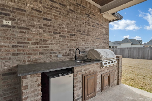 view of patio / terrace featuring a sink, exterior kitchen, fence, and grilling area