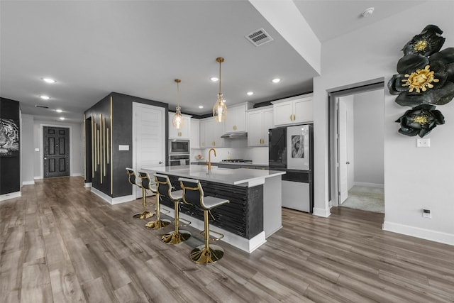 7436 Whisterwheel Way, Fort Worth, TX 76123 - kitchen featuring visible vents, appliances with stainless steel finishes, white cabinetry, and wood finished floors
