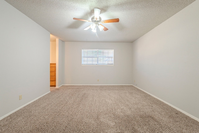 spare room featuring light carpet, a textured ceiling, baseboards, and ceiling fan