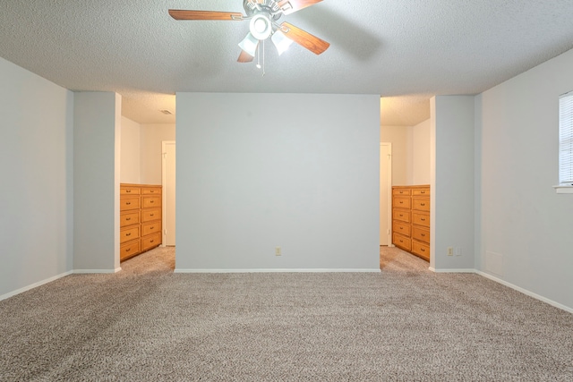 unfurnished bedroom with light carpet, a textured ceiling, and baseboards