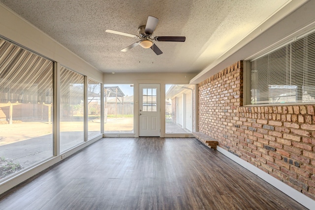 unfurnished sunroom featuring a ceiling fan