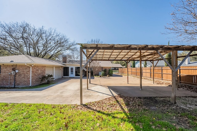view of patio with a pergola, fence, and a garage
