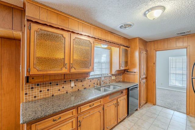 kitchen with dishwasher, brown cabinetry, visible vents, and a sink