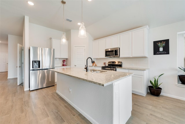 kitchen featuring visible vents, a kitchen island with sink, a sink, stainless steel appliances, and light wood-type flooring