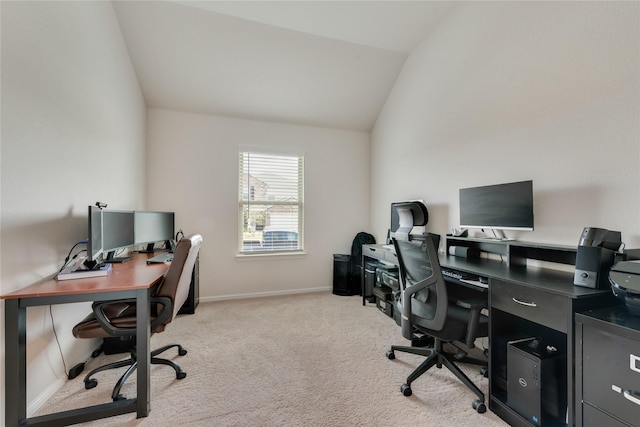 office featuring baseboards, lofted ceiling, and light colored carpet