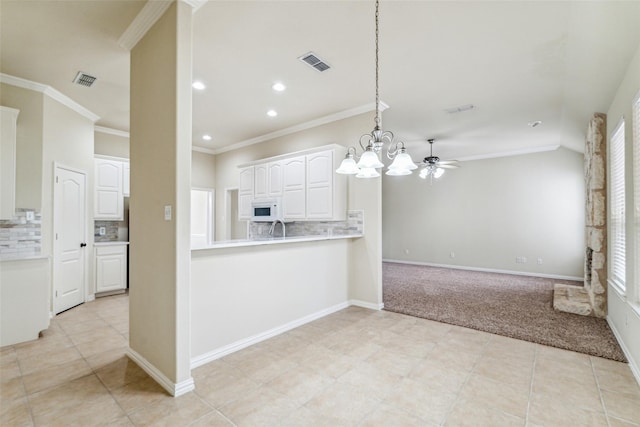 3104 Rim Rock Ct, Granbury, TX 76049 - kitchen featuring white microwave, visible vents, crown molding, light countertops, and white cabinetry