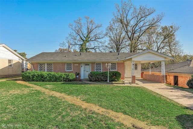 ranch-style home featuring brick siding, an attached carport, concrete driveway, and a front yard