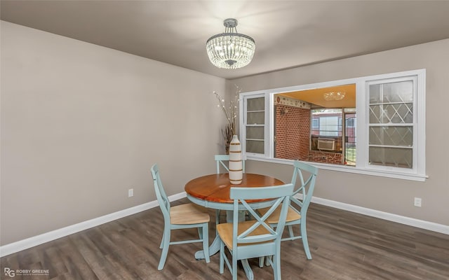 dining space with a notable chandelier, baseboards, and wood finished floors