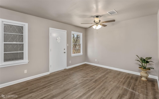 foyer entrance featuring wood finished floors, visible vents, baseboards, and ceiling fan