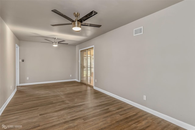 empty room with visible vents, wood finished floors, baseboards, and ceiling fan