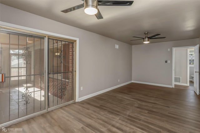 spare room with visible vents, baseboards, ceiling fan, and wood finished floors