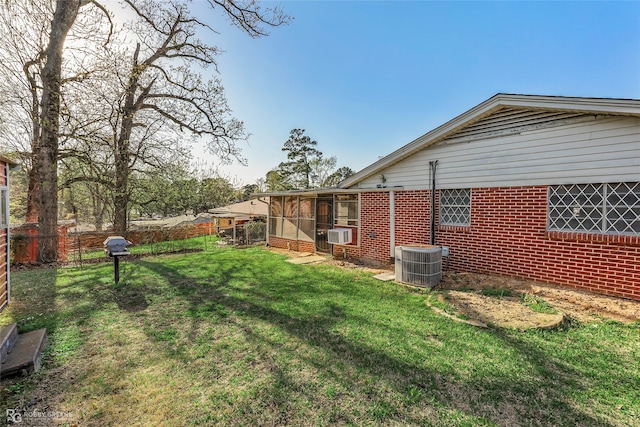 view of yard with cooling unit, a sunroom, central AC, and fence