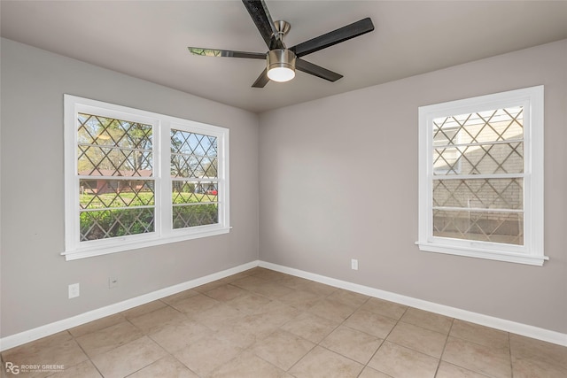 spare room featuring light tile patterned floors, baseboards, and ceiling fan