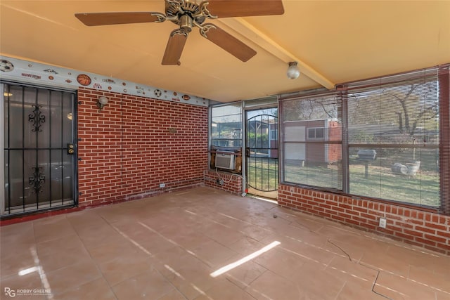 unfurnished sunroom with beam ceiling and ceiling fan