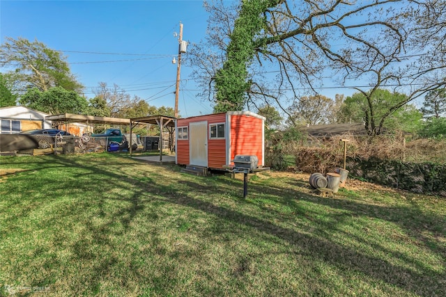 view of yard with a storage unit, a carport, and an outdoor structure