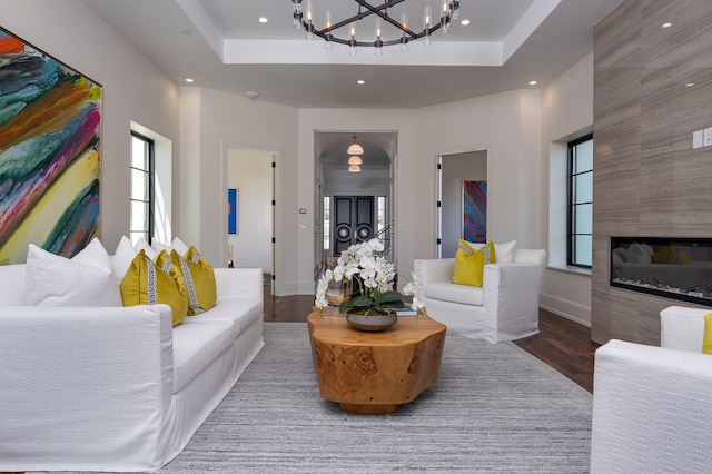 1230 Oak View Ct, Oak Point, TX 75068 - living area with wood finished floors, a raised ceiling, a chandelier, recessed lighting, and a tiled fireplace