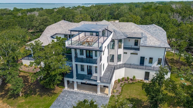 1230 Oak View Ct, Oak Point, TX 75068 - view of front of home with a balcony, stucco siding, a view of trees, and driveway