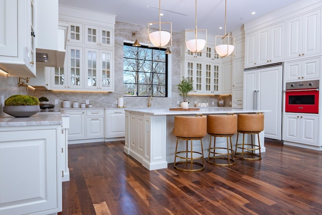 1230 Oak View Ct, Oak Point, TX 75068 - kitchen with wall oven, a center island, white cabinetry, light countertops, and dark wood-type flooring