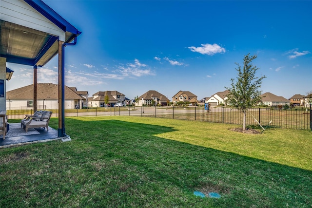 view of yard featuring a patio area, fence, and a residential view