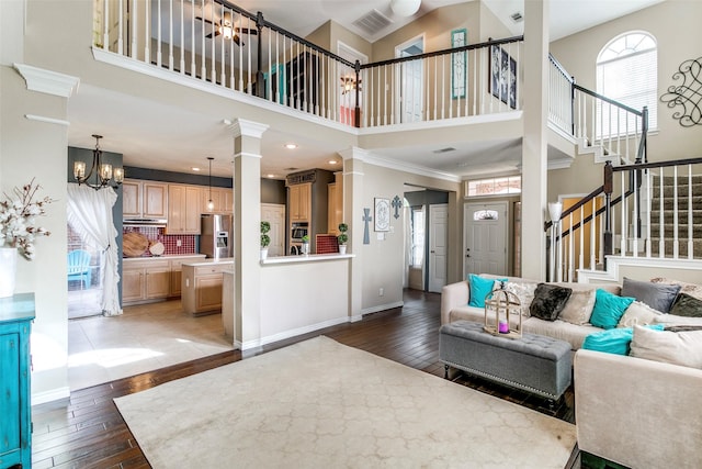 227 Moss Hill Rd, Irving, TX 75063 - living area featuring a high ceiling, plenty of natural light, a chandelier, wood-type flooring, and stairway