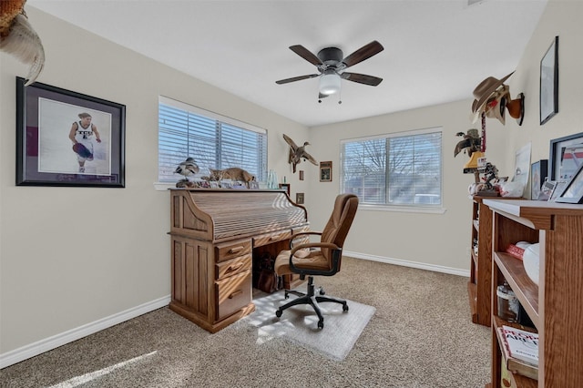 office area with carpet flooring, a ceiling fan, and baseboards