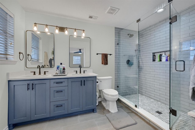 full bathroom with visible vents, a stall shower, toilet, and a sink