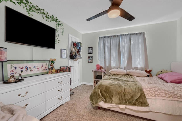 bedroom with light carpet, baseboards, and a ceiling fan