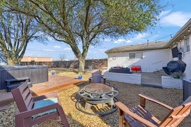 view of yard featuring a patio, a fire pit, a fenced backyard, and a hot tub