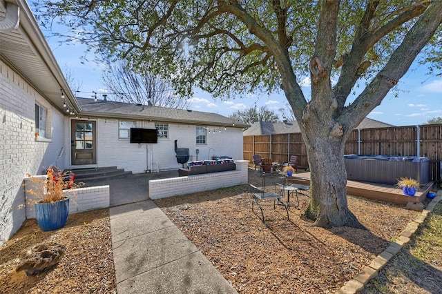 view of yard featuring an outdoor living space, a fenced backyard, entry steps, a jacuzzi, and a patio area