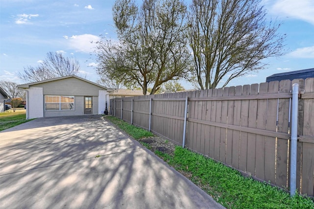 exterior space featuring concrete driveway and fence